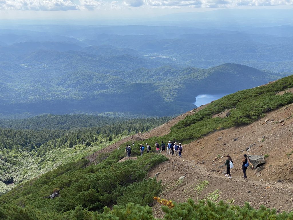 Students walk down a gravel path on a hike through the mountains in Japan