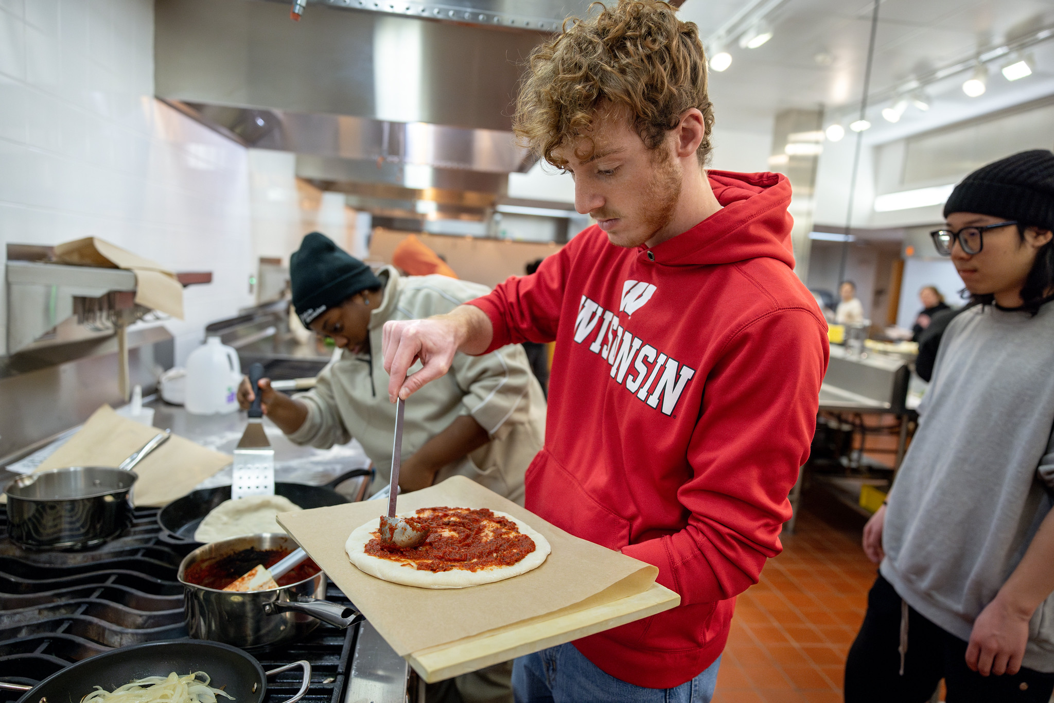 Two students make pizza in a kitchen lab
