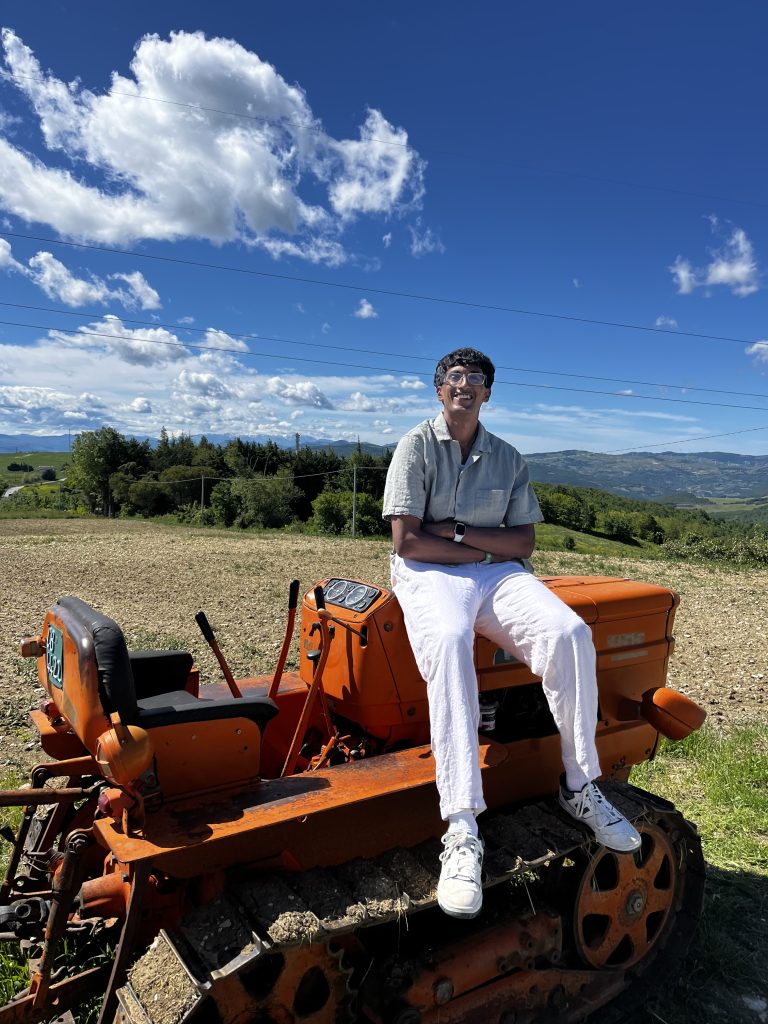 A student sits on a tractor in the Italian countryside